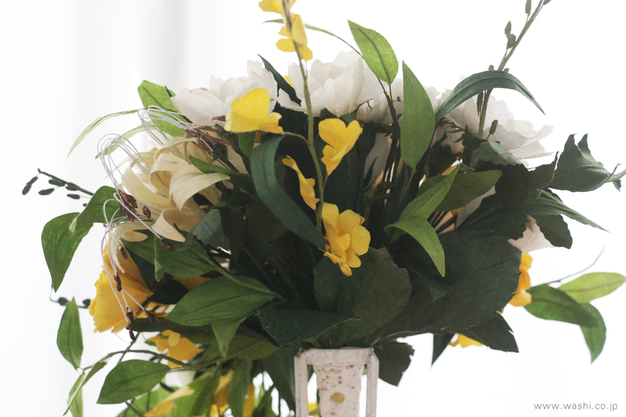 和紙のブーケ側面クローズアップ。鮮やかな緑の葉と、白・黄色の花々。