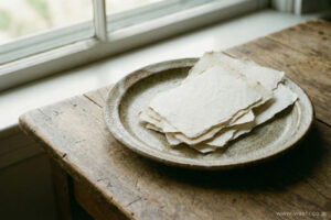陶器の皿の上に重ねて置かれた手漉き和紙
